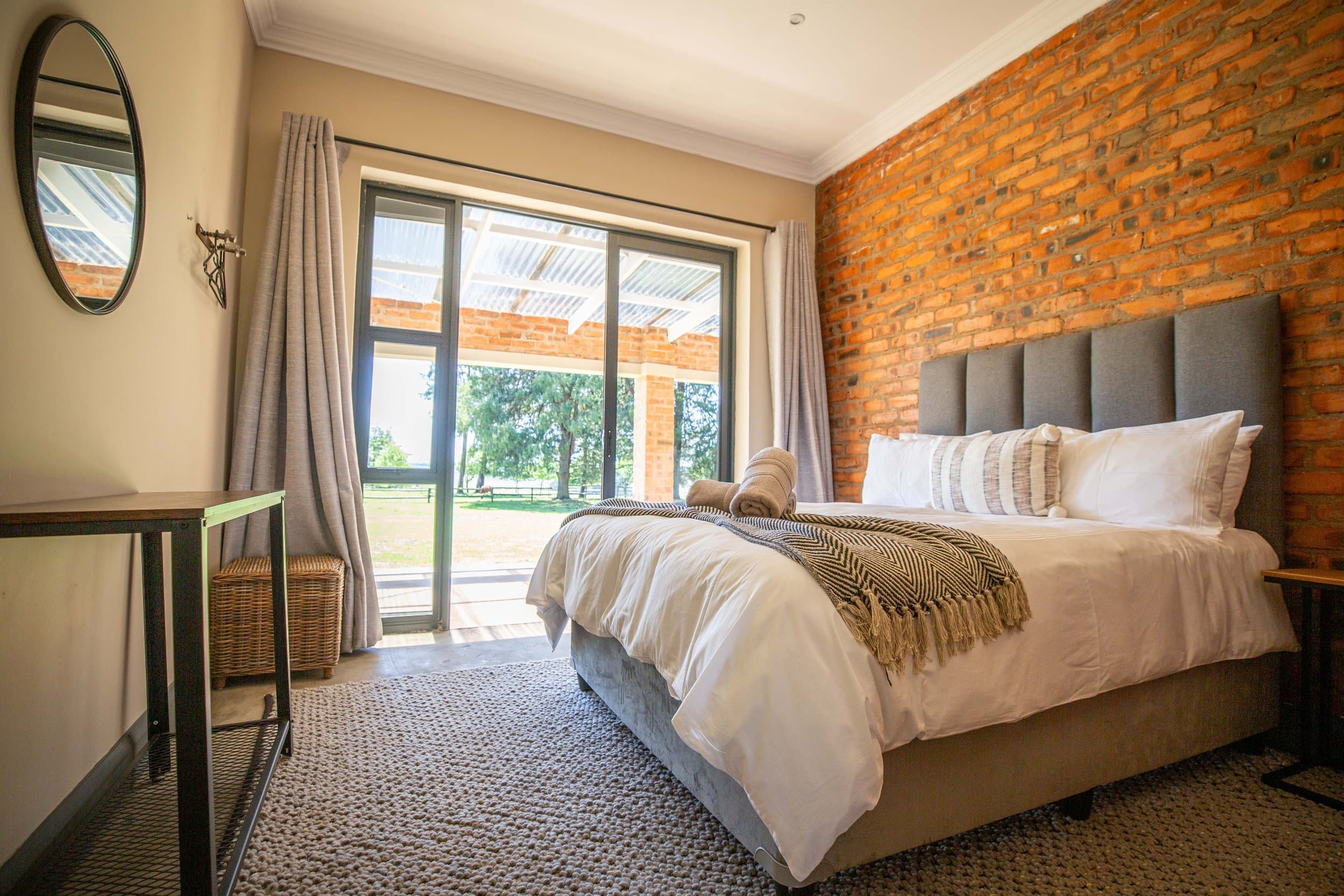 Queen bed and brick feature wall in a Netherwood Annex room